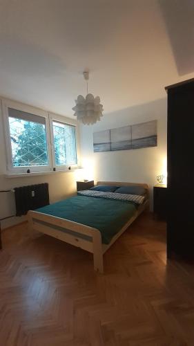 um quarto com uma cama num quarto com duas janelas em Krzemieniecka Atlas Arena Zoo Orientarium em Łódź