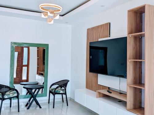 uma sala de estar com televisão e duas cadeiras em Homestay in Kigali, Rusororo em Masaka