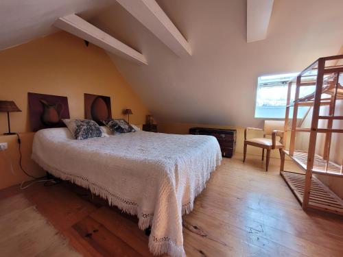 1 dormitorio con 1 cama grande y una escalera en L'Ostel Aveyronnais, en Golinhac