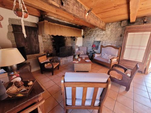 sala de estar con muebles y chimenea de piedra. en L'Ostel Aveyronnais, en Golinhac