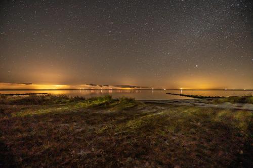 a starry night over a body of water at Nysted Strand Camping & Cottages in Nysted
