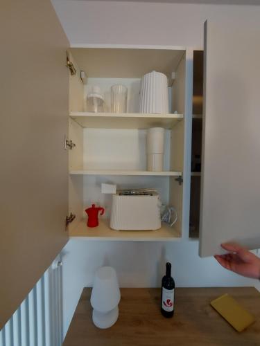een keukenkast met borden en ander keukengerei bij Tiny House Tower in Fidenza