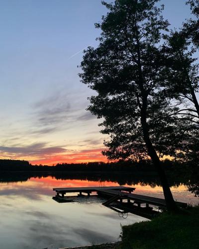 a picnic table and a dock on a lake at sunset at Folwark Mazurskie Legendy - Azyl dla Dorosłych in Kruklanki