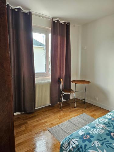 une chambre avec un lit, une table et une fenêtre dans l'établissement Charmante maison familiale, à Montoire-sur-le-Loir