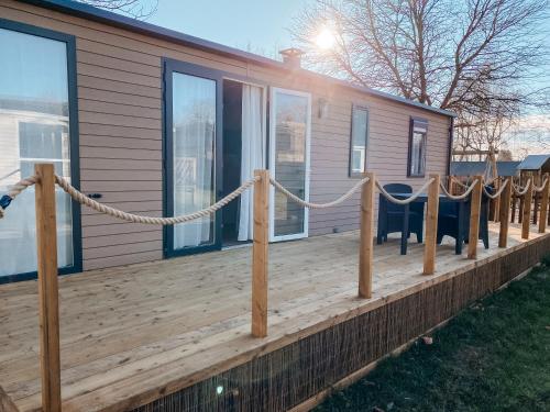 una terraza de madera con una cuerda en una casa en Rêve d'été - Camping Belle-Vue 2000, en Berdorf