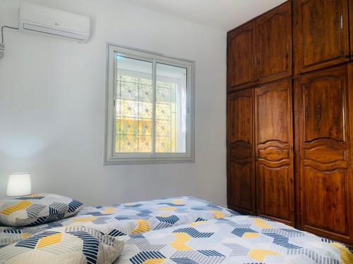 1 dormitorio con 1 cama, vestidor y ventana en Dar chenini, en Gabès