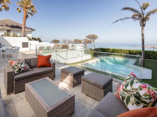 une terrasse meublée et une piscine dans l'établissement Villa Galazzio, au Cap