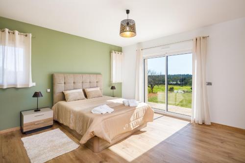 1 dormitorio con cama y ventana grande en Villa Le Verger 15 minutes de Faro, en Estói