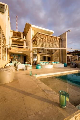 a large building with a pool in front of it at DCO Suites Lounge & Spa in Máncora