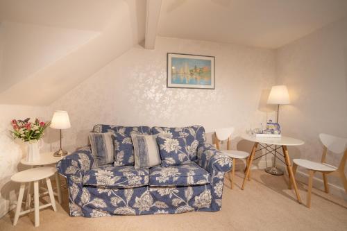 a living room with a blue couch and tables at Barnes Fell Apartments in Ambleside