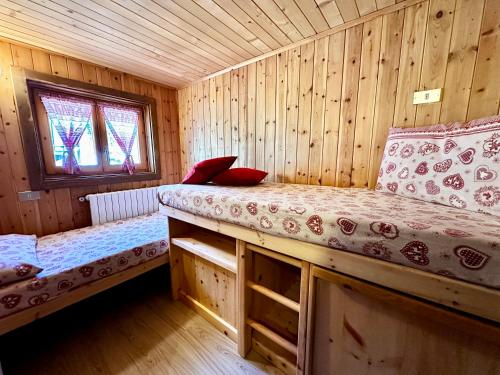 博爾米奧的住宿－Chalet Bormino 6，小木屋内一间卧室,配有两张床