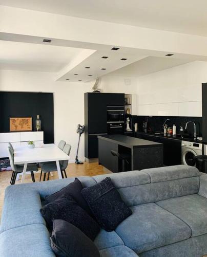 un salon avec un canapé bleu et une cuisine dans l'établissement ECRIN AU COEUR DE PARIS PRES DU JARDIN DU LUXEMBOURG, à Paris