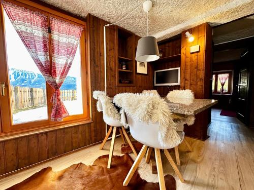 a dining room with a table with white chairs at Chalet Bormino 6 in Bormio
