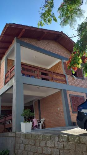uma casa com uma varanda com uma mesa e cadeiras em Alma leve! em Florianópolis
