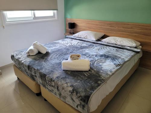 a bedroom with a bed with two towels on it at Palm Sea Suite 17 in Larnaka