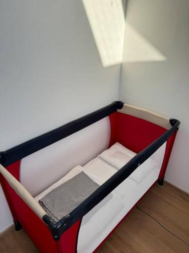 a small red and white bed in a room at Juwel am Stadtrand von Wien in Korneuburg