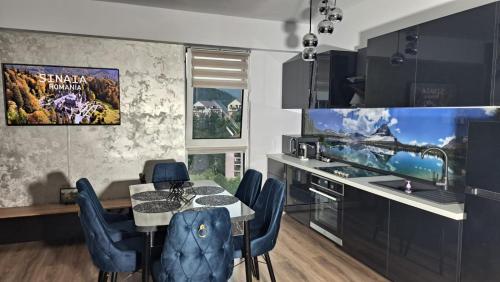 a kitchen with a dining table and blue chairs at Anastasia Luxury Apartment in Sinaia