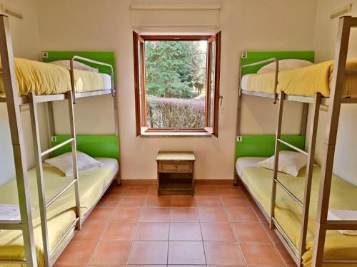 a room with four bunk beds and a window at HI Geres - Pousada de Juventude do Gerês in Geres