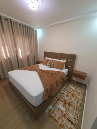 1 dormitorio con 1 cama grande con sábanas blancas en Hout founty en Agadir