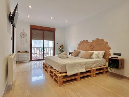 una camera con un grande letto su una piattaforma di legno di Casa con jacuzzi y piscina con vistas al castillo a Corbera de Alcira