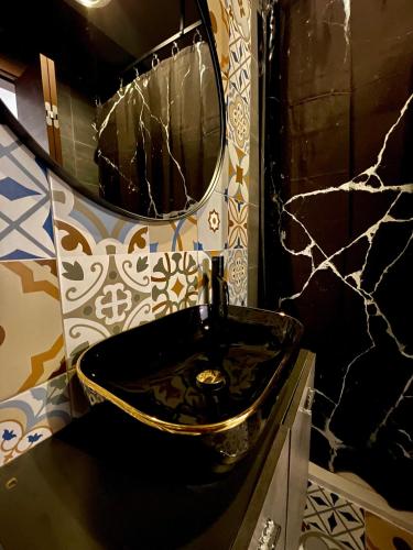 a bathroom with a black sink and a mirror at Airport Accommodation Bedroom with your own private Bathroom Self Check In and Self Check Out Air-condition Included in Mqabba