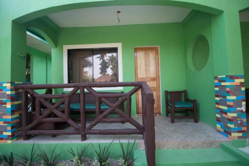 Habitación con paredes verdes y balcón de madera. en Moonlight Resort, en Isla de Malapascua