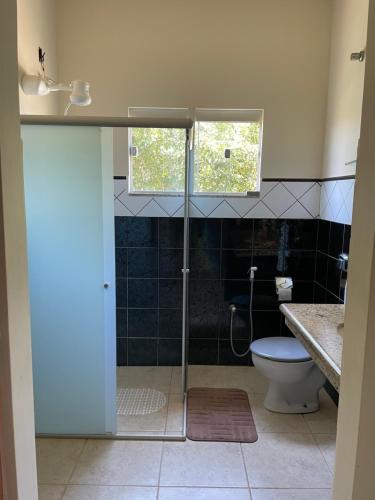 a bathroom with a shower with a toilet and a window at Espaço Verde in São Mateus
