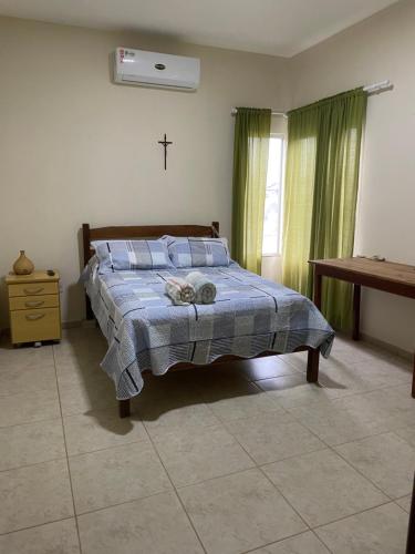 a bedroom with a bed with a cross on the wall at Espaço Verde in São Mateus