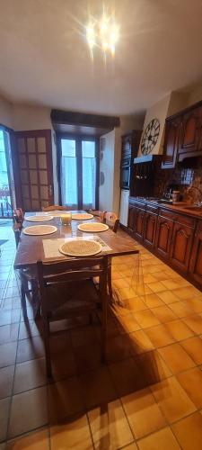 a dining room with a table and a kitchen at gîte la tanière de claire in Ségur