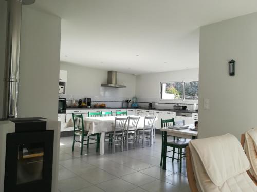 une cuisine avec une table, des chaises et une cuisinière dans l'établissement Maison au calme proche des plages du Golfe du Morbihan, à Baden