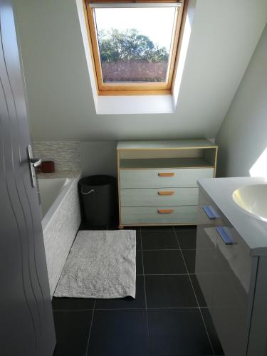 une petite salle de bains avec un lavabo et une lucarne. dans l'établissement Maison au calme proche des plages du Golfe du Morbihan, à Baden