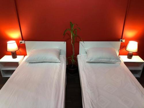 two beds in a room with two lamps at Econom Hostel in Yerevan
