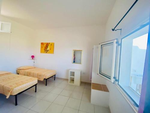 Habitación con 2 camas y ventana en Casa Vacanze Sofimar con Trullo, en Leuca