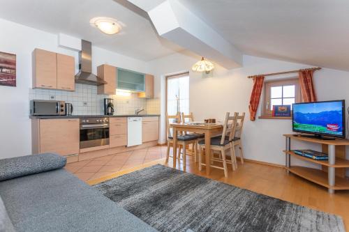 a living room with a kitchen and a table with a television at Ferienwohnungen Lahner in Bramberg am Wildkogel
