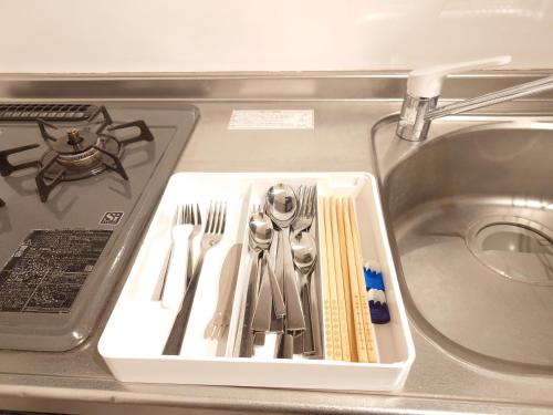 a tray of utensils sitting in a sink at NIYS apartments 53 type in Tokyo
