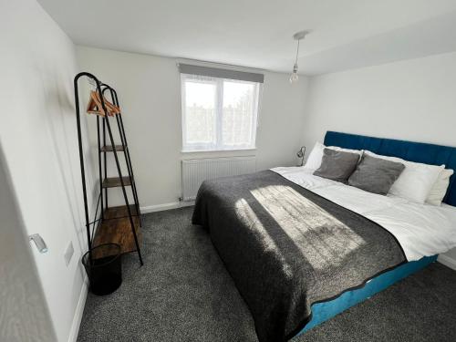 a bedroom with a large bed with a blue head board at Luxury, 3 Bed, 2 Bathroom, Free Private Parking in Oxford