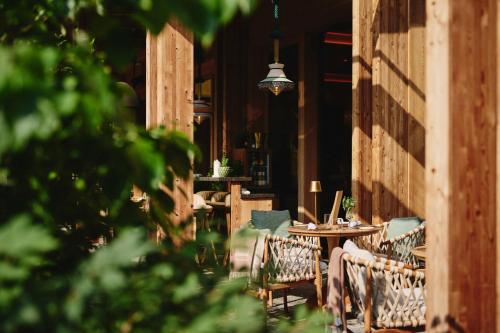 a patio with tables and chairs in a building at MalisGarten Green Spa Hotel - Adults Only in Zell am Ziller