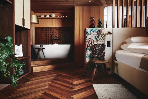 a room with a tub and a painting on the wall at MalisGarten Green Spa Hotel - Adults Only in Zell am Ziller
