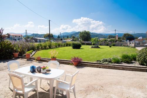 a white table and chairs with a view of a park at Ruellia Luxury Apartments in Lefkada Town
