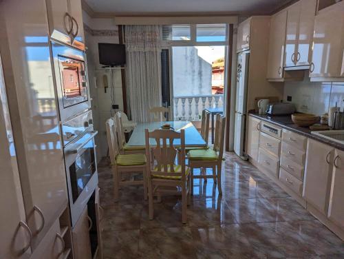 a kitchen with a table and chairs and a window at Casa Adora mit 3 Schlafzimmern, Garten und Meerblick in Santa Úrsula
