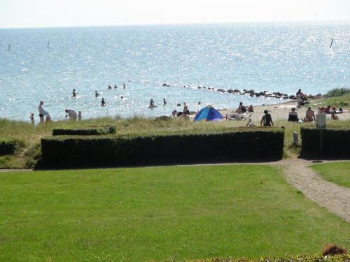 a group of people on a beach near the water at Nysted Strand Camping & Cottages in Nysted