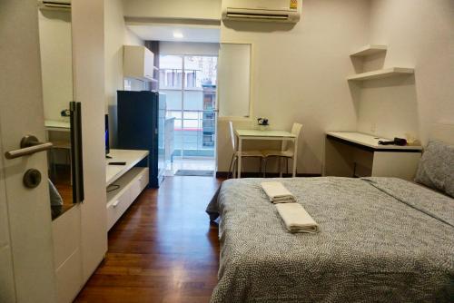 a small room with a bed and a small kitchen at Sathon 15 apartment close to BTS Skytrain St Louis & Surasak in Bangkok