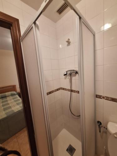 y baño con ducha y puerta de cristal. en Hostal Pension - La Rotonda, en Tardienta