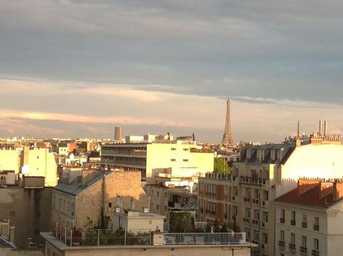 a view of a city with the eiffel tower at 2 bedrooms in the sky ! in Neuilly-sur-Seine