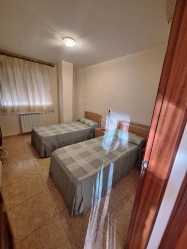 a room with two beds and a window at Hostal Pension - La Rotonda in Tardienta