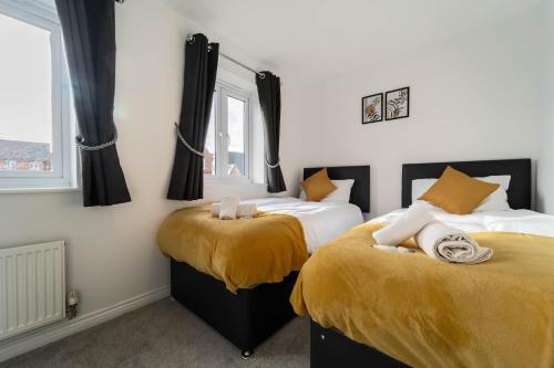 1 dormitorio con 2 camas con sábanas amarillas en Modern 2 Bed Didcot Home (Free Parking), en Didcot