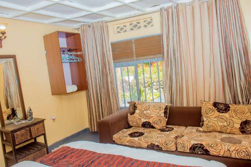 a living room with a couch in front of a window at COLIBRI VILLA City Center in Gisenyi