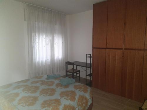 Schlafzimmer mit einem Bett, einem Tisch und einem Fenster in der Unterkunft Spazioso Appartamento in casa singola Padova con giardino in Padua