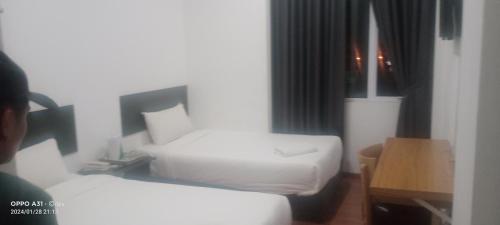 ein Hotelzimmer mit 2 Betten und einem Tisch in der Unterkunft hotel seri liny in Kuching