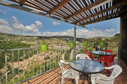 a patio with a table and chairs on a balcony at נגיעות בטבע - צימרים כפריים מקסימים כולל ארוחת בוקר ובריכה מחוממת in Bet Dagan